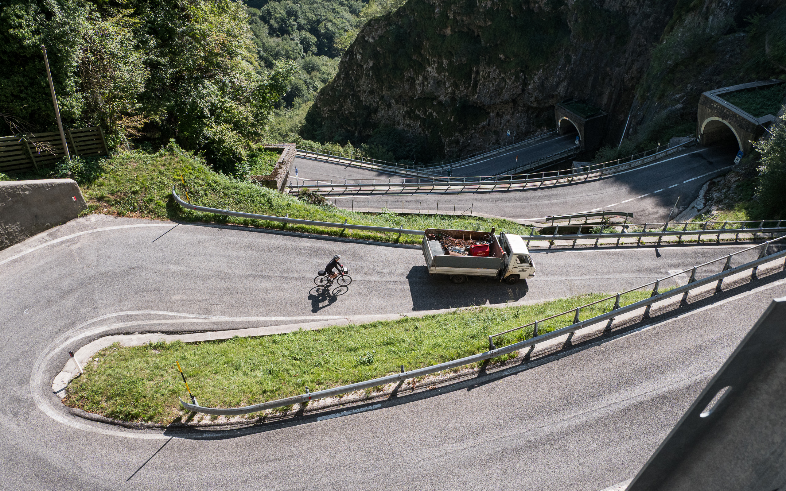 Die Kehren des Passo San Boldo von oben – ein Radler und ein Ape auf der Straße